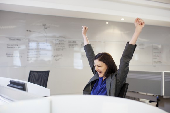 Businesswoman celebrating at her desk.