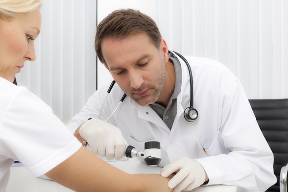 Doctor examines female patient for skin cancer