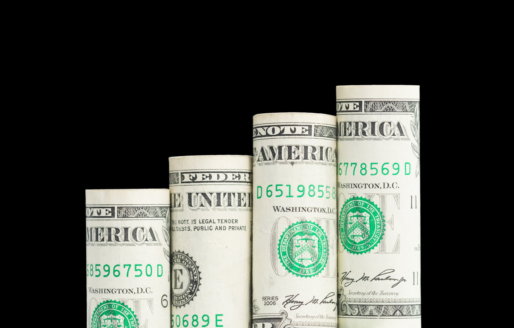 Progressively taller rolls of dollar bills standing side by side. 