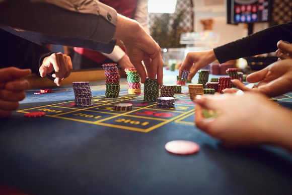Gamblers placing chips on a roulette table.