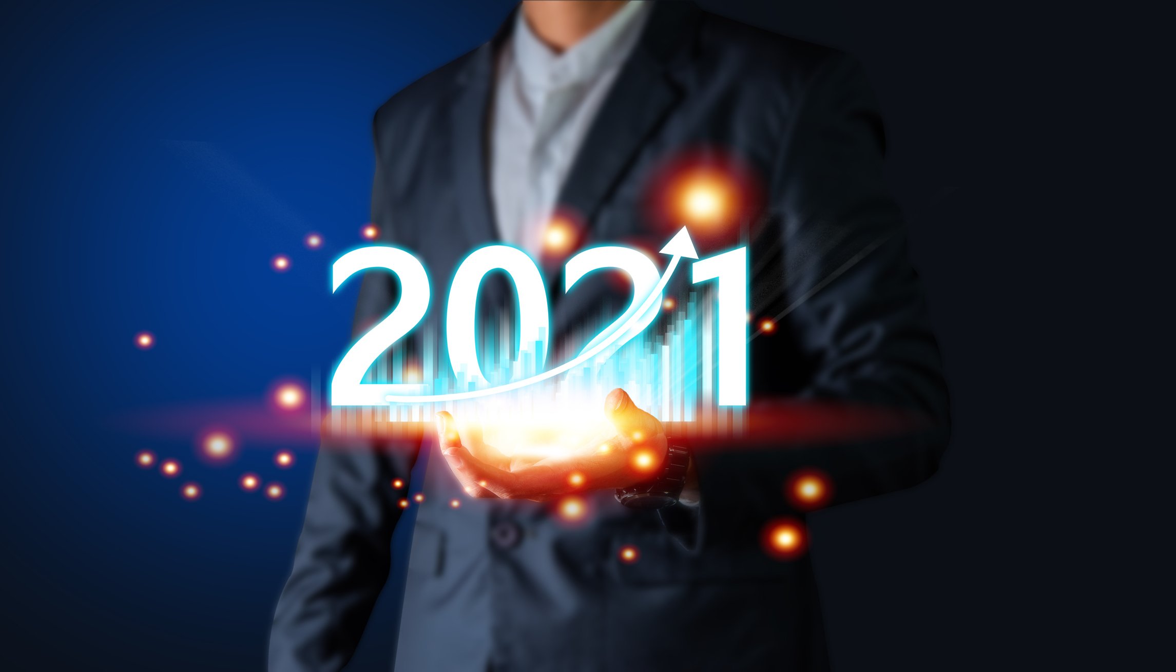A man holding a tablet displaying a chart and the number 2021.