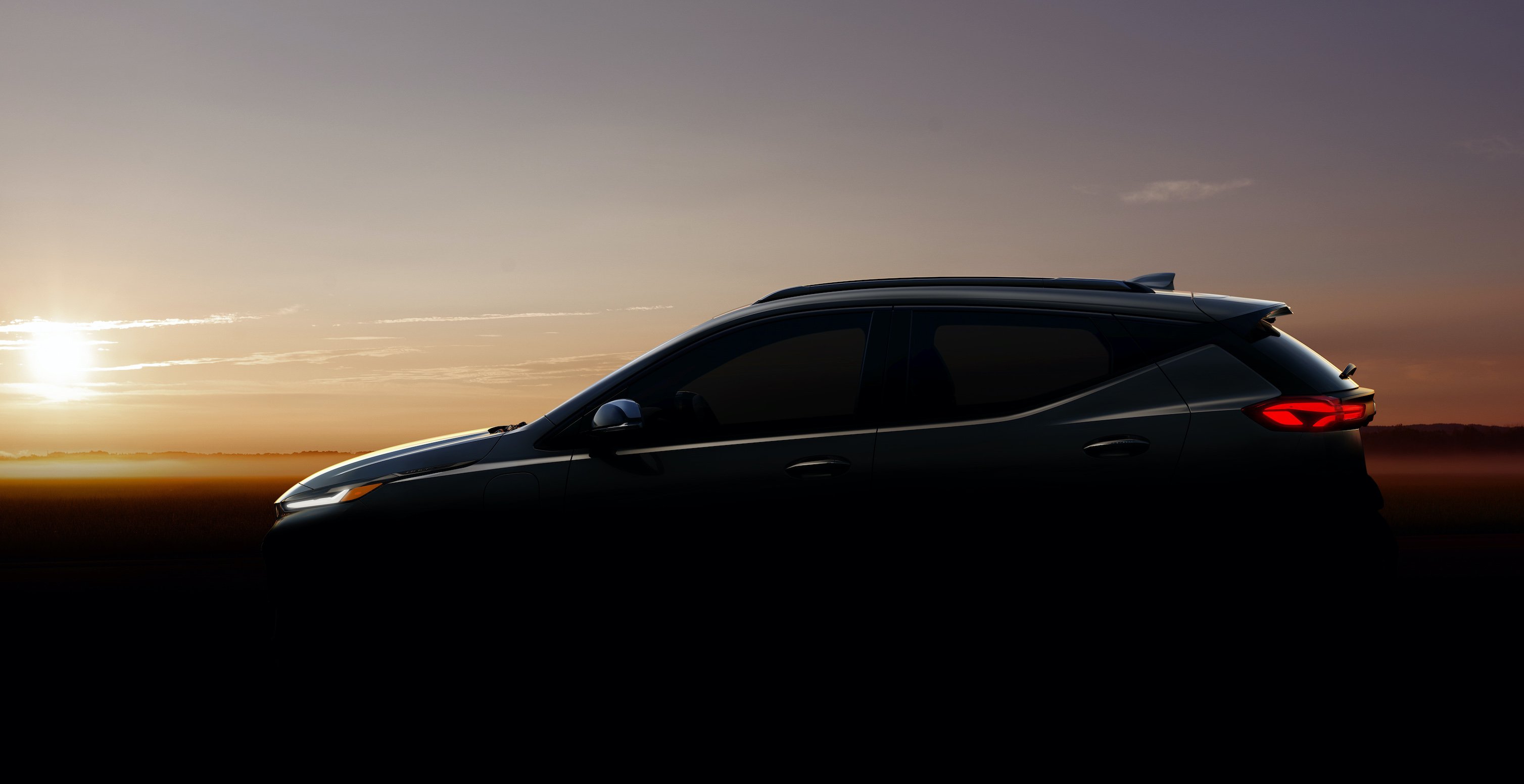 A darkened photo of a small electric SUV based on the Chevrolet Bolt electric car. 
