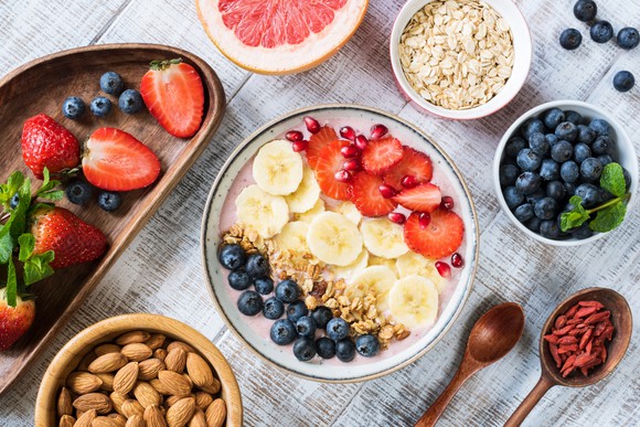 An assortment of fresh fruit and toppings arranged around an acai bowl