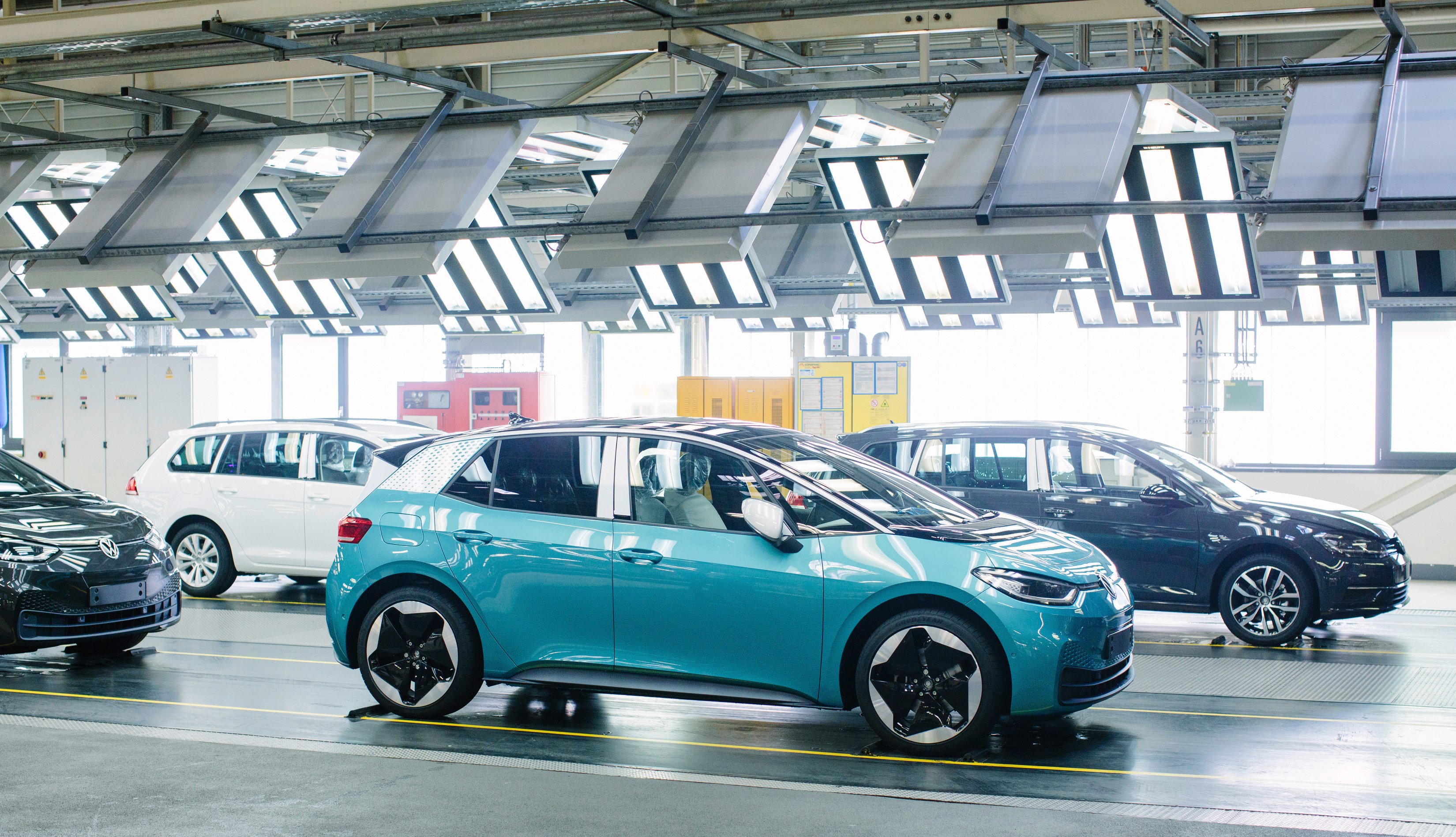 Several VW ID.3 electric hatchbacks are shown in an auto factory. 