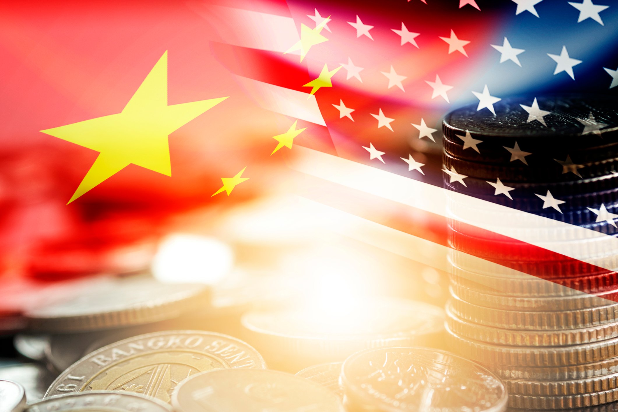 U.S. and China flags superimposed above a picture of coins.
