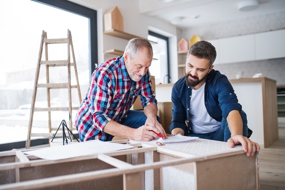 An older man and a younger man working on a home-improvement project.