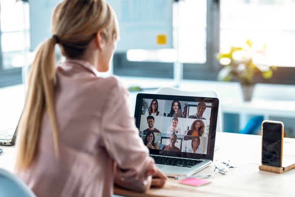 Woman on video meeting with nine others. 