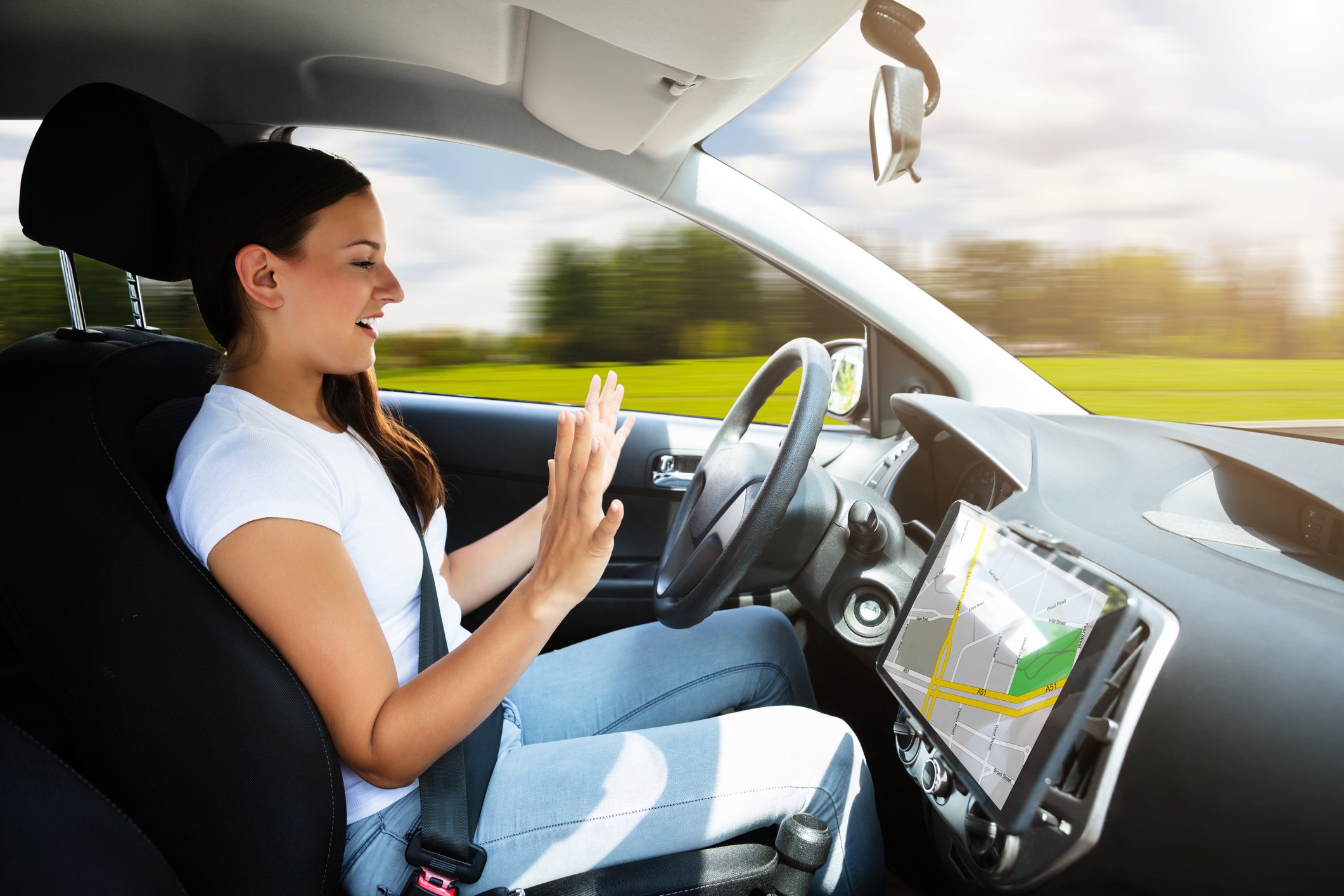 Woman keeping her hands off the steering wheel of a self-driving car.