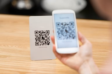 Hand holding a smartphone scanning a QR code