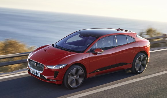 A red Jaguar I-Pace, an electric luxury crossover SUV.