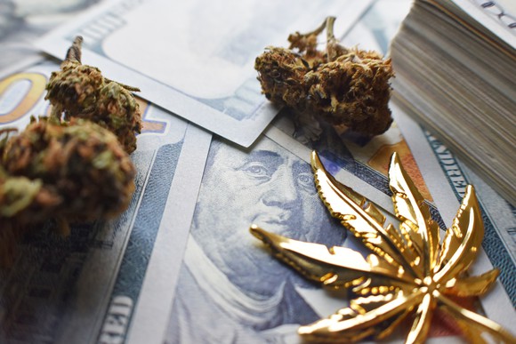 Gold cannabis leaf, cannabis buds, and cash