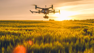 Drone flying over field at sunset getty