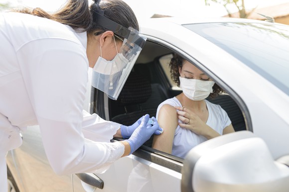 Car passenger receiving a vaccination shot.
