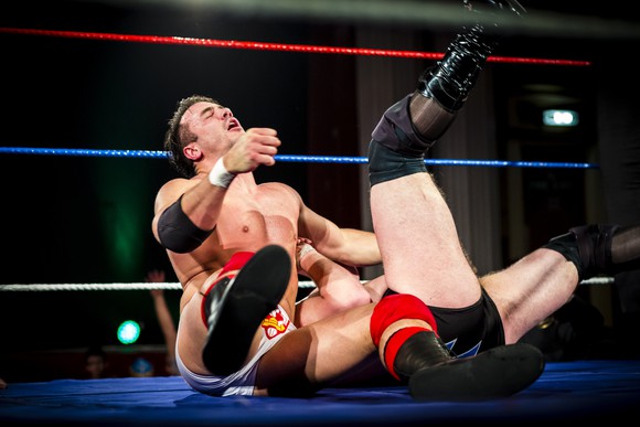 Two pro wrestlers fighting in a ring.