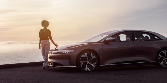 Woman standing by a Lucid Air sedan