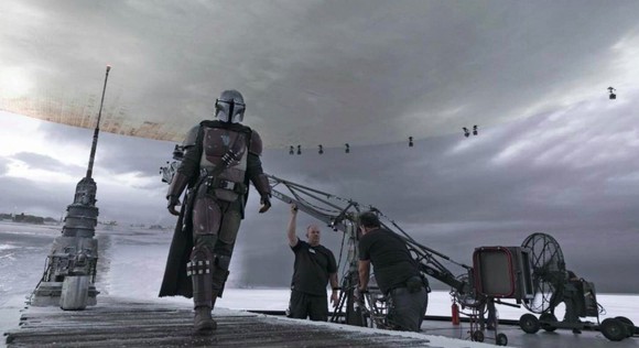 The Mandalorian walks across the StageCraft soundstage during production of the show.