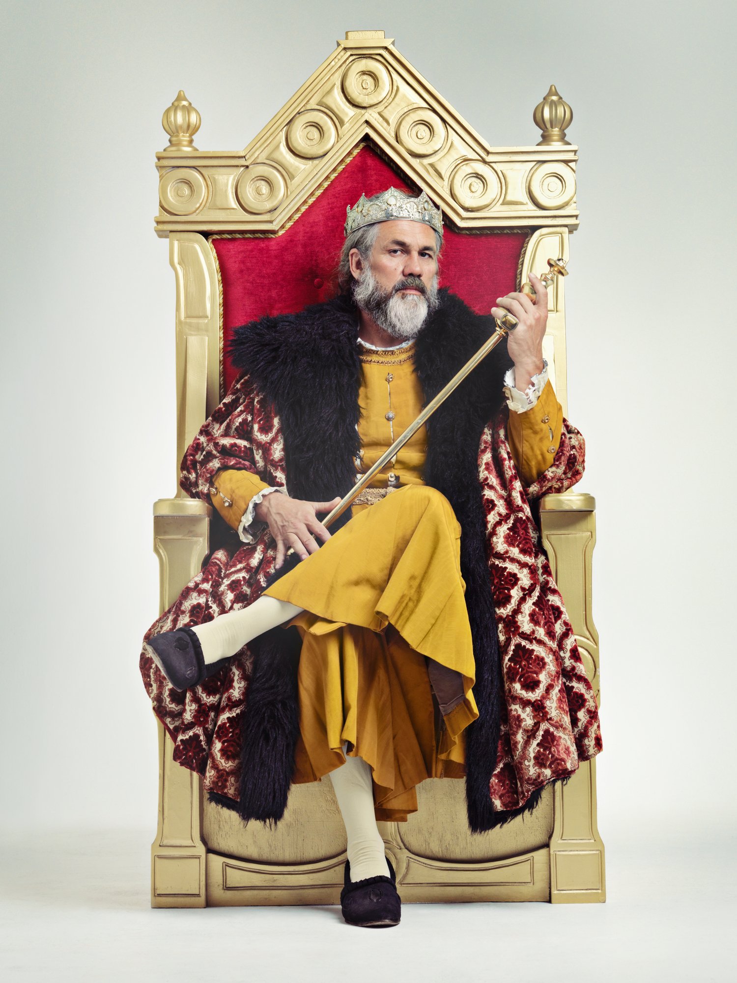 King in royal robes, sitting on gilded throne