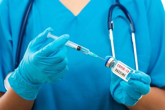 A doctor draws up a dose of coronavirus vaccine.