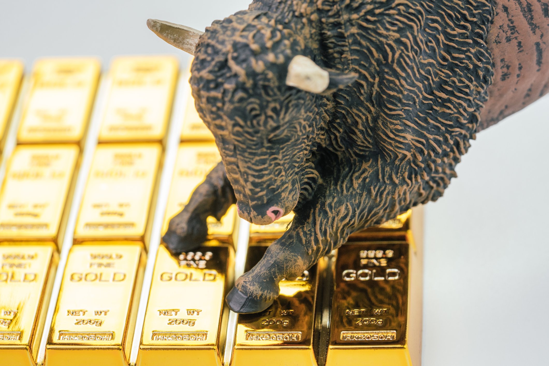 Bull jumping onto gold bullion bars.