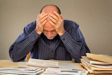 frustrated man looking at bills