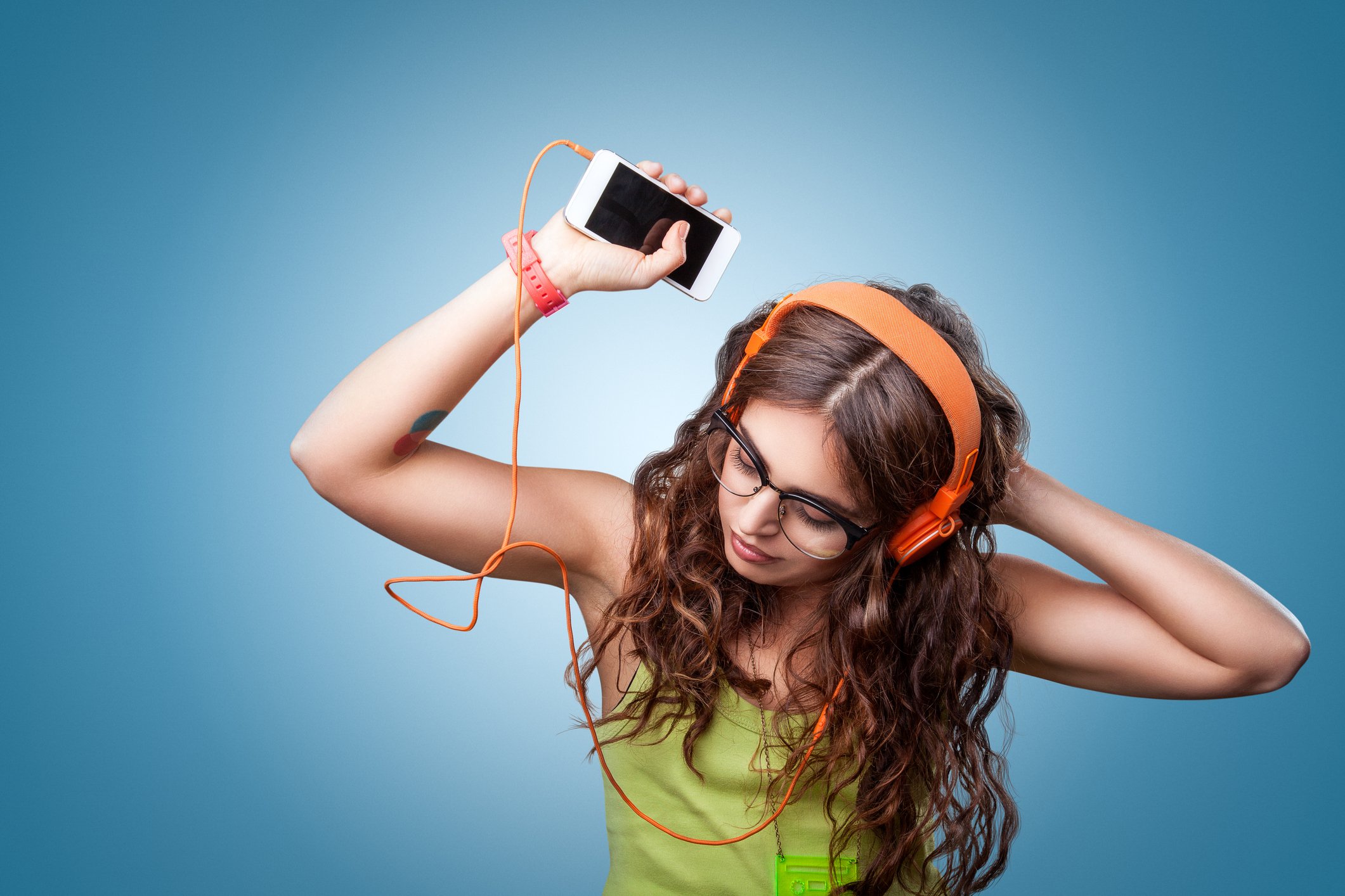 A young woman listens to music on her phone.