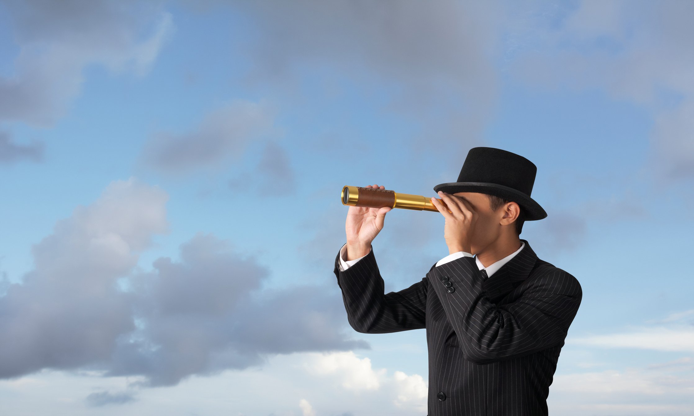 A businessperson looking through a telescope.