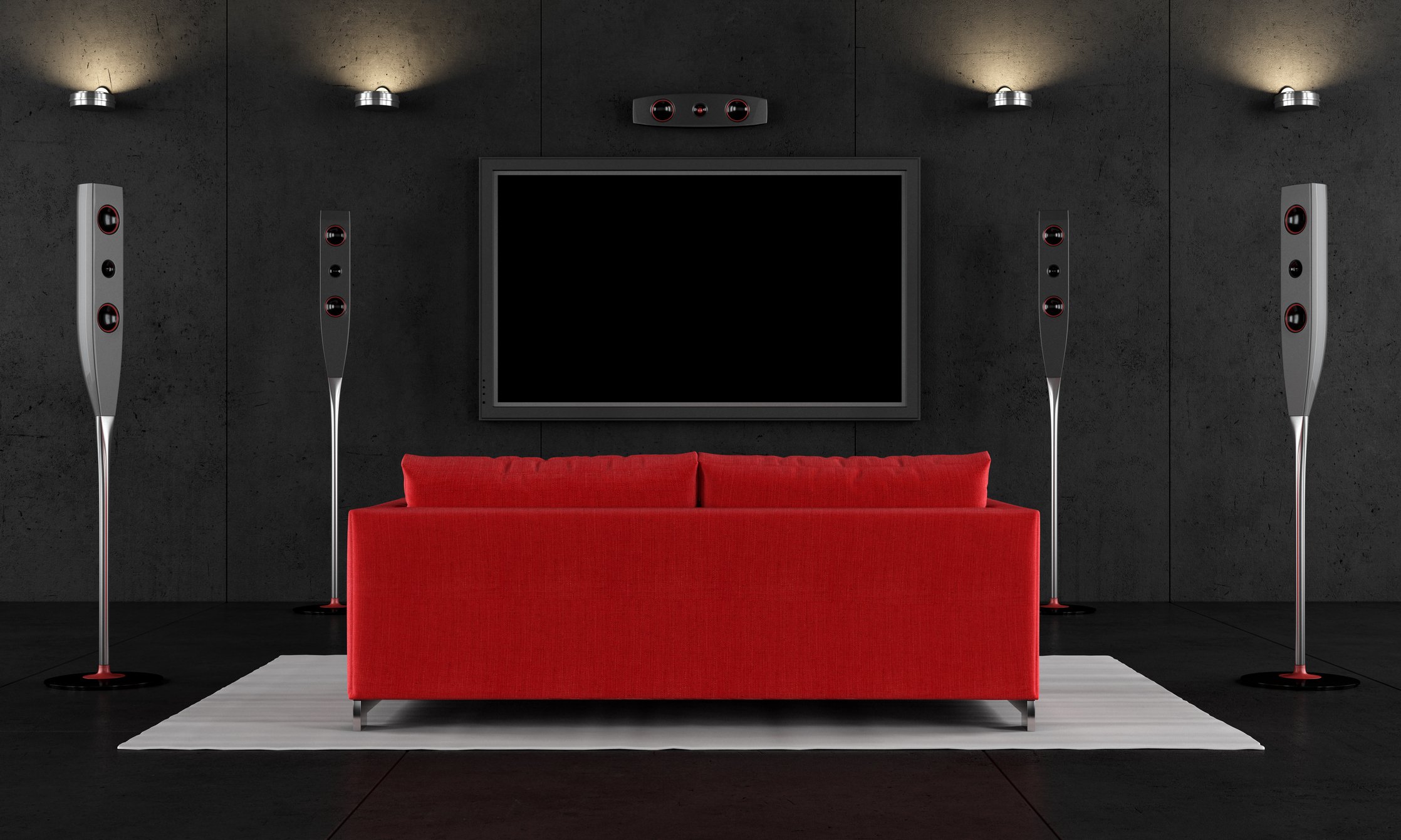 A red couch in a living room in front of a large TV screen.