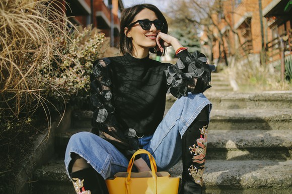Woman wearing fashionable clothes and sunglasses.