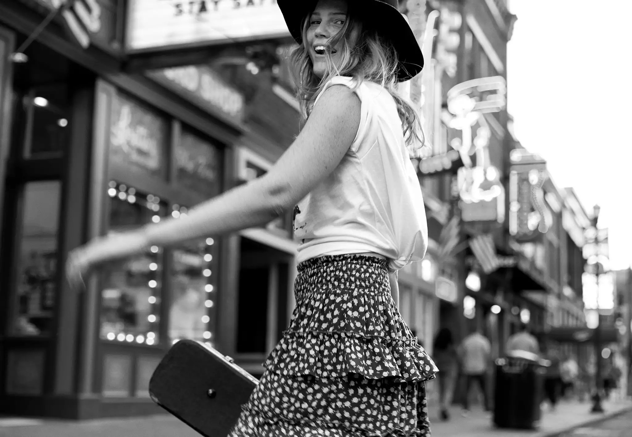 A young woman turns around on a downtown street.