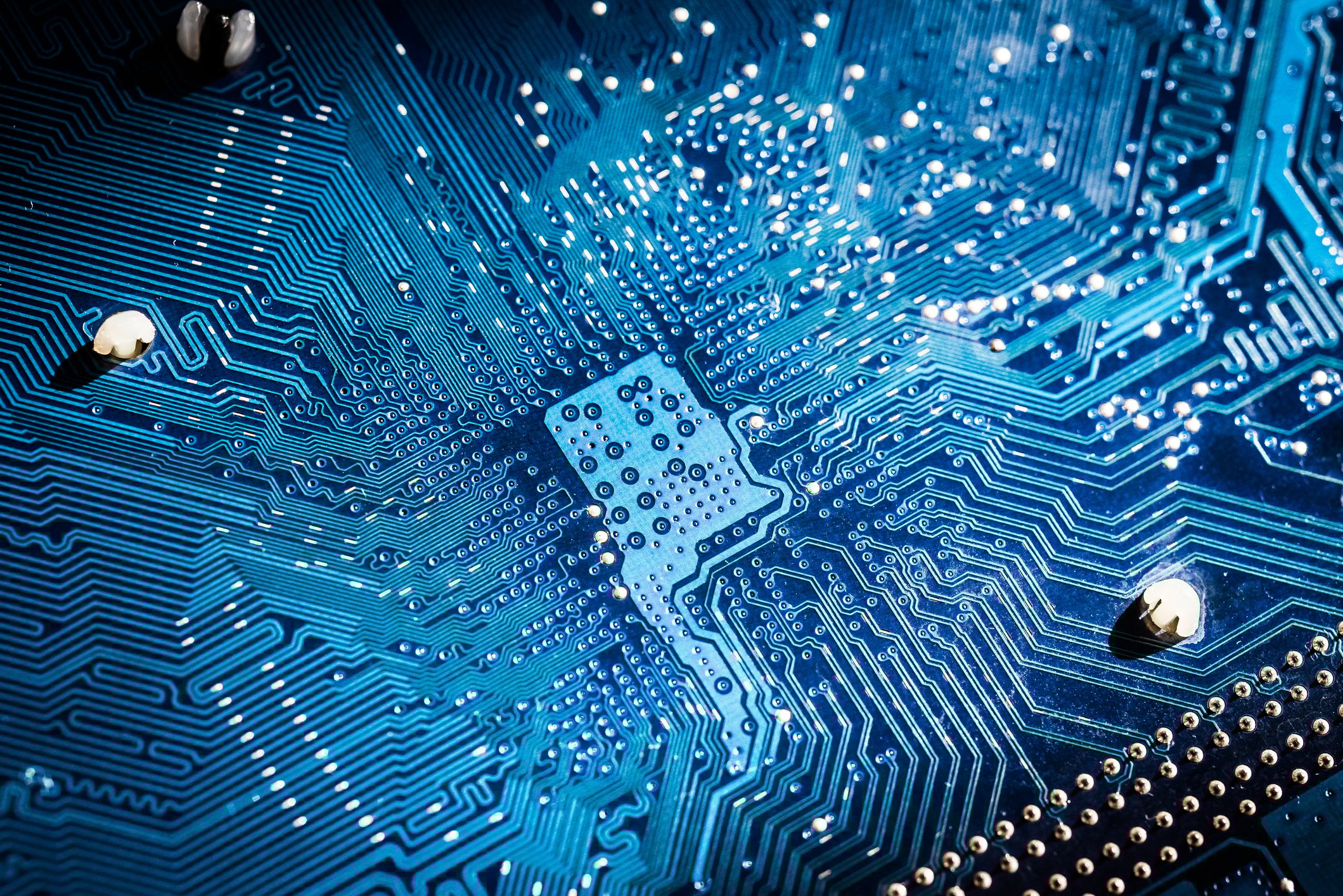 Closeup of a circuit board illuminated in blue. 