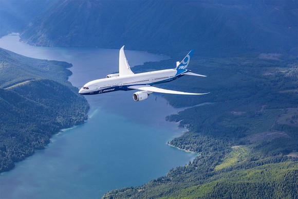A Boeing 787 Dreamliner flying over a river