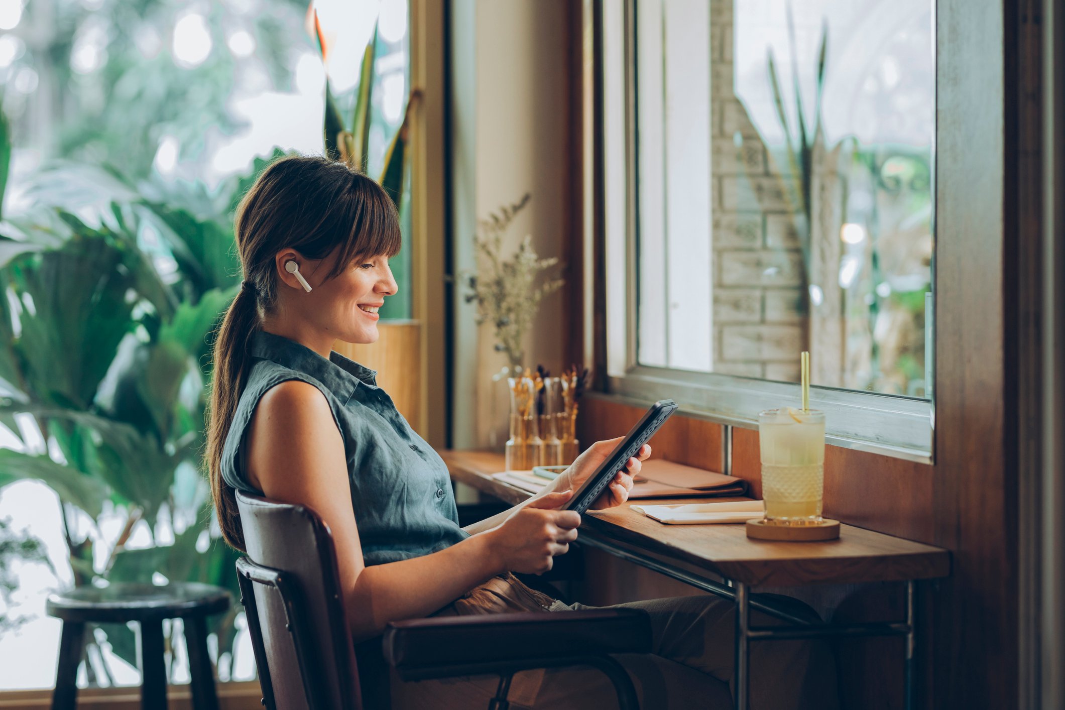 A woman with a computer and a glass of lemonade.