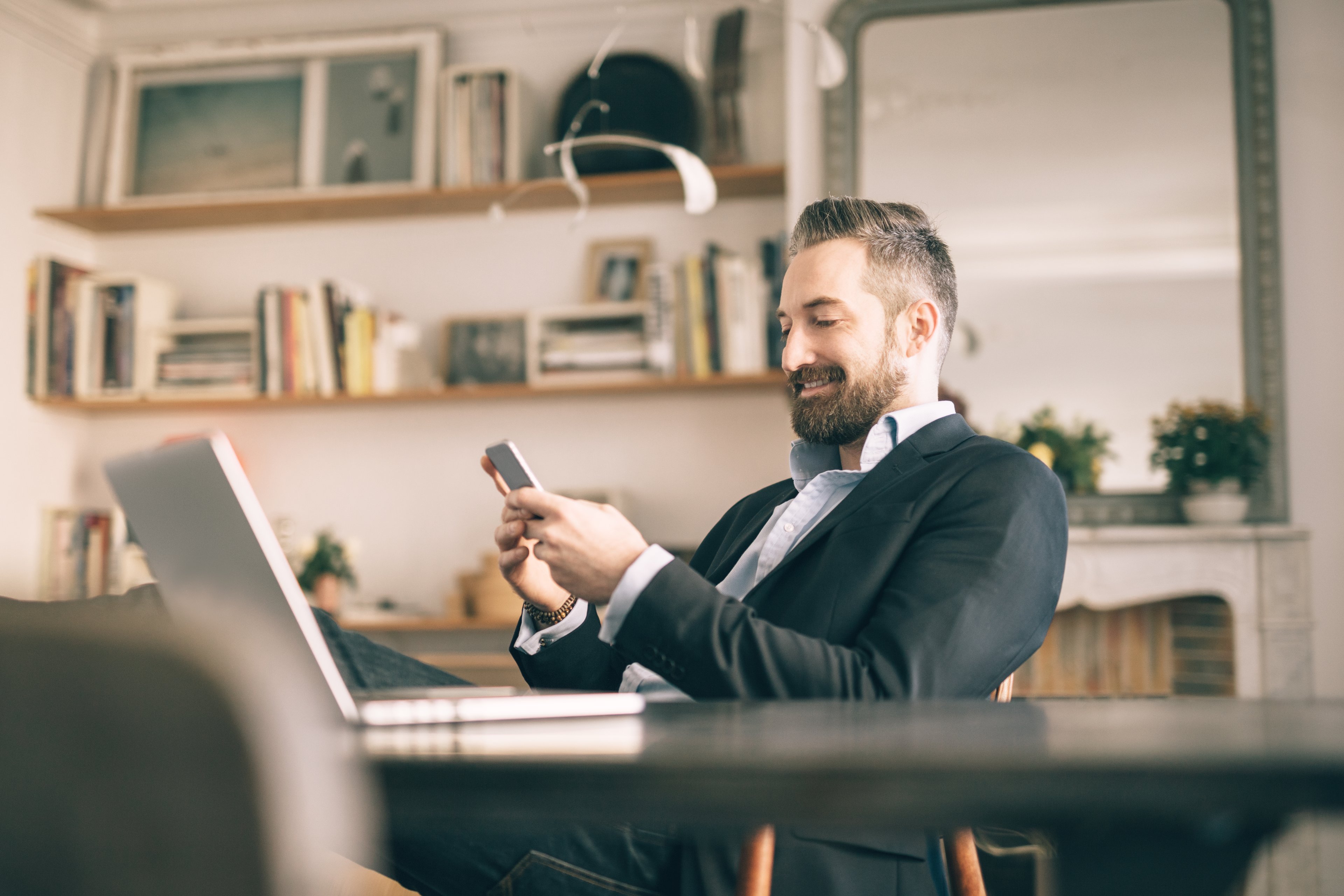 Man using smartphone in home office. 