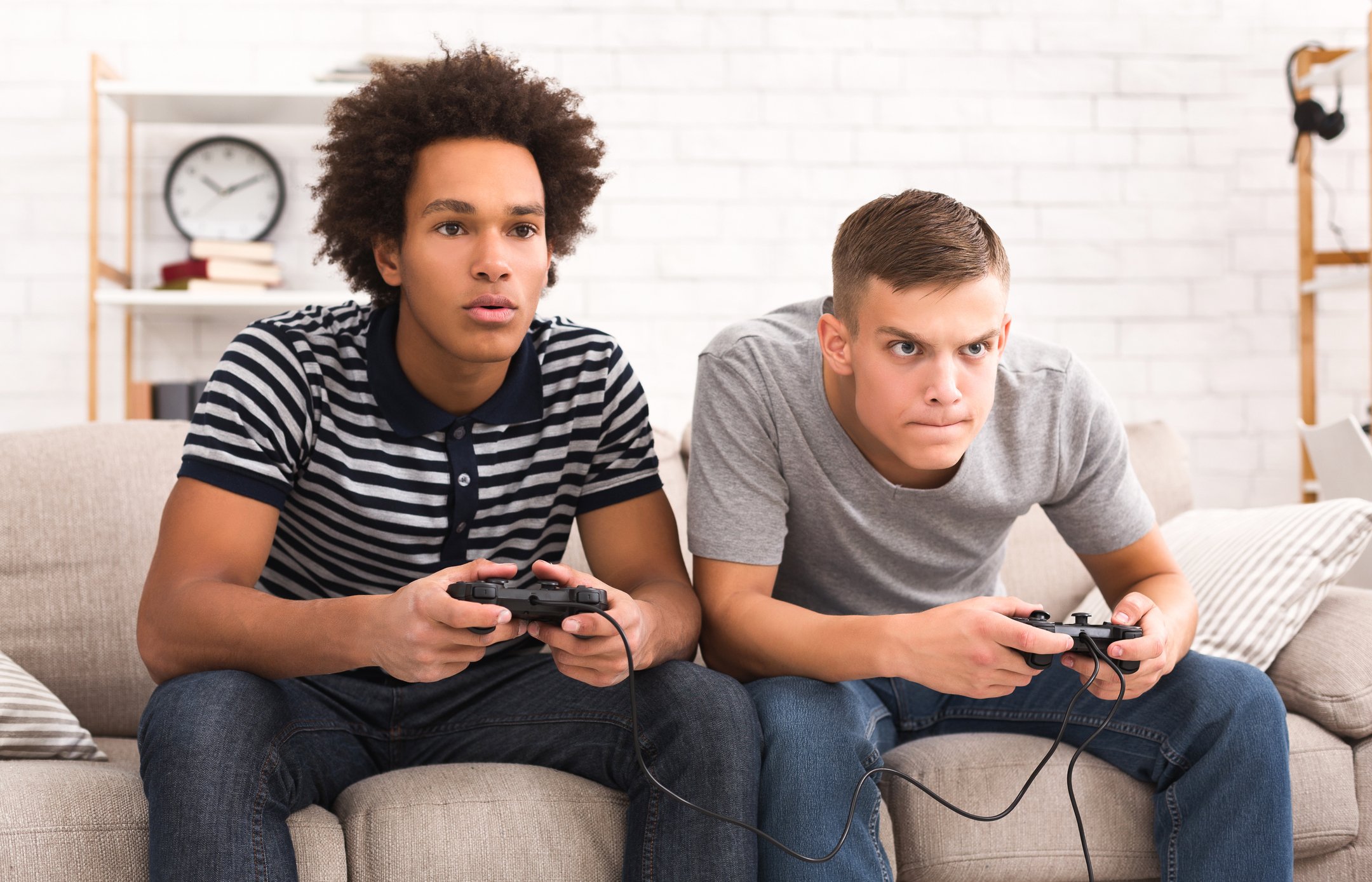 Two men focused on playing a video game