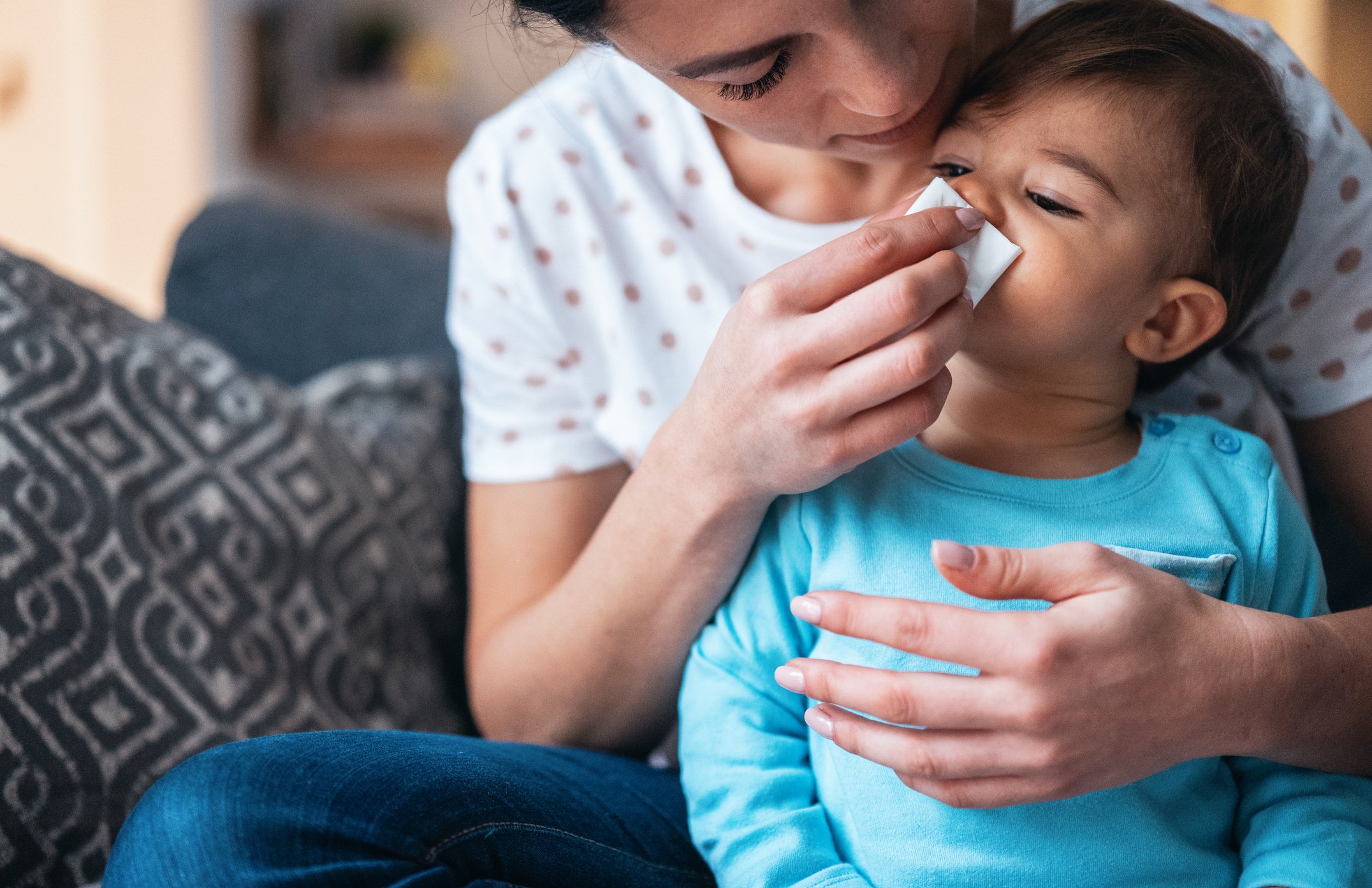 Woman wiping child's nose