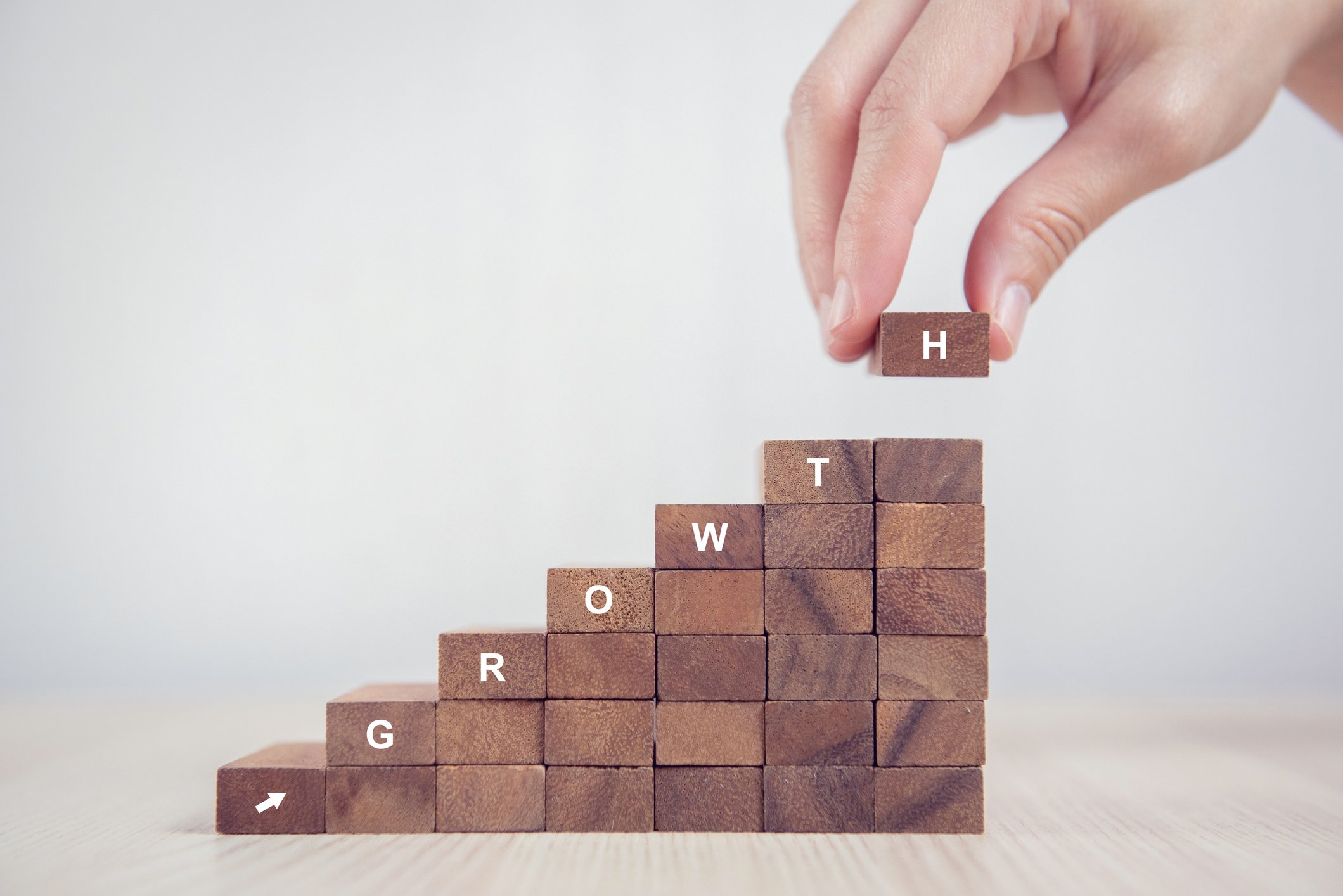 Upward sloping stack of blocks with the letters spelling the word growth going left to right and up. 