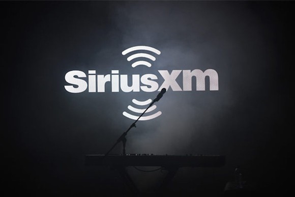 Sirius XM logo with microphone over a black background.