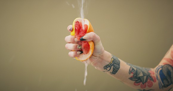 Hand squeezing a grapefruit