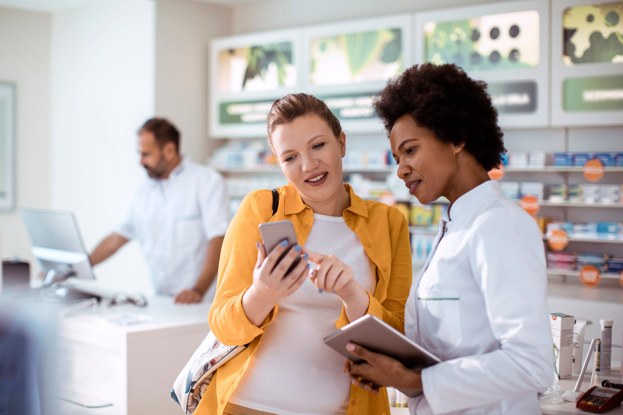 Customer receiving help with her smartphone from a service rep at a phone store.