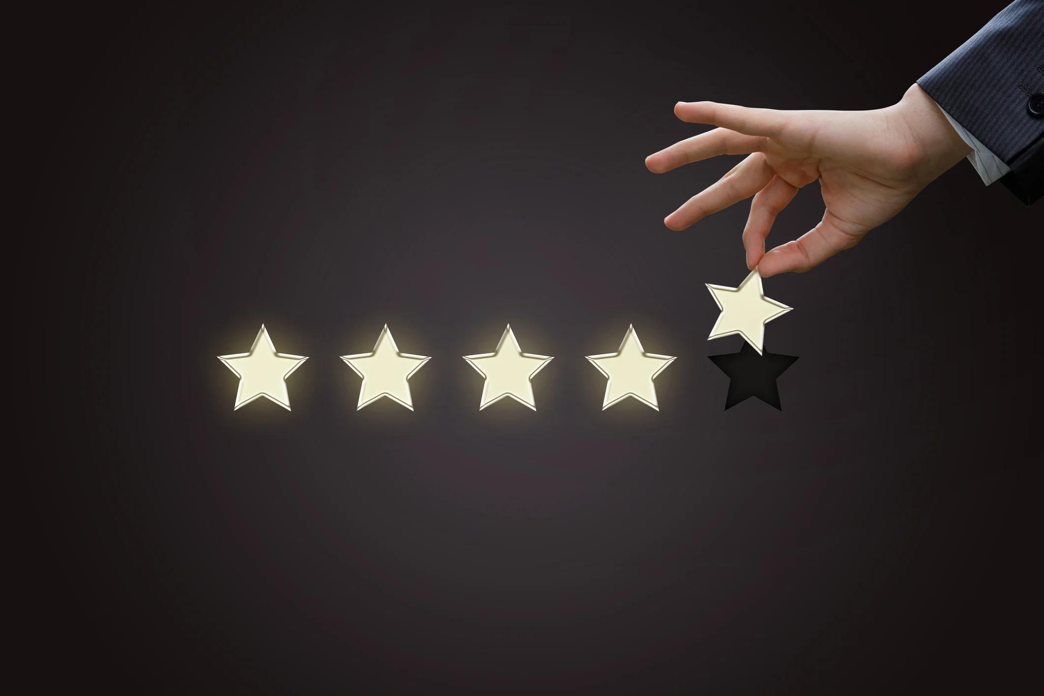 Hand placing five bright stars in a row on a dark background.