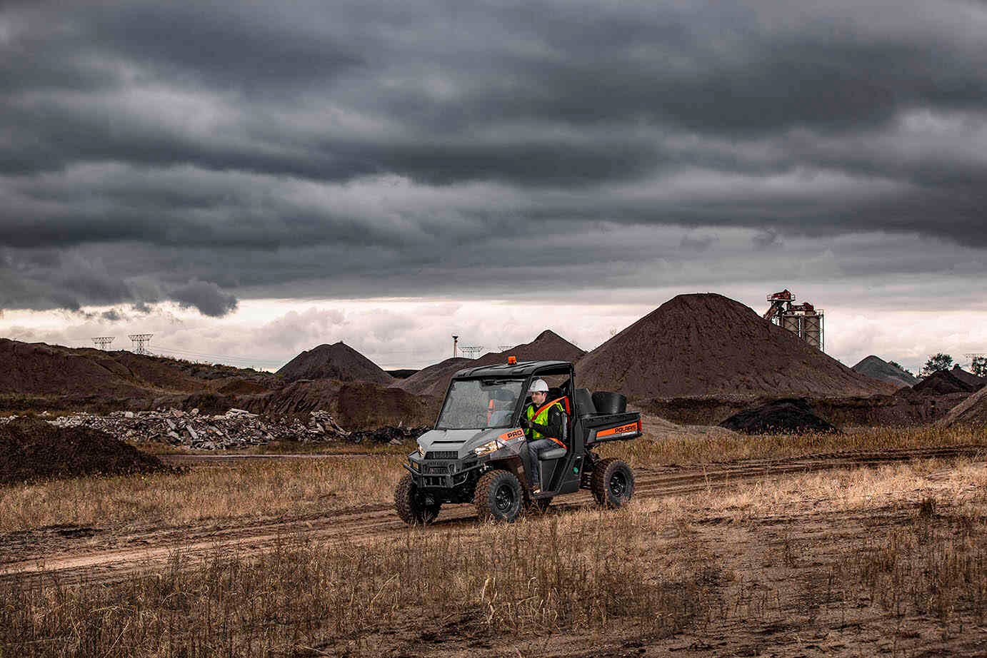 A worker driving a Polaris commercial vehicle.