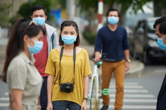 Chinese people on the street wearing protective masks for COVID-19