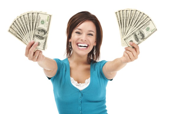 Smiling investor holding $100 bills fanned in both hands