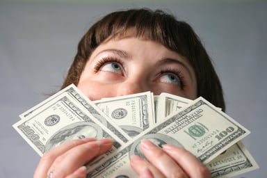 woman smelling 100 bills --GettyImages-101749466
