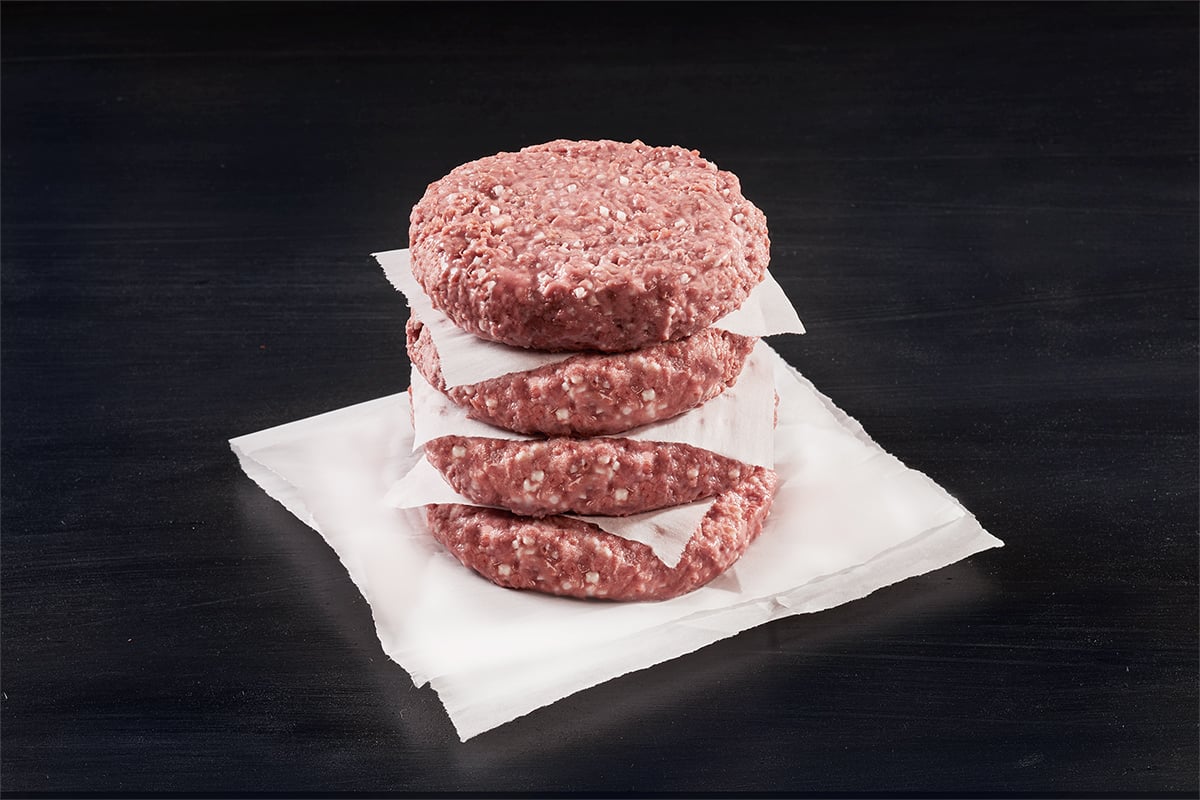 A stack of four burger patties made with Beyond Meat's Beyond Beef.