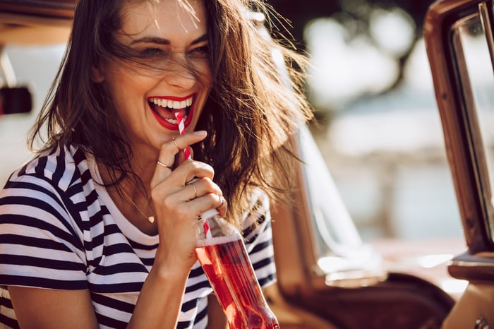 A woman drinking soda from a straw.