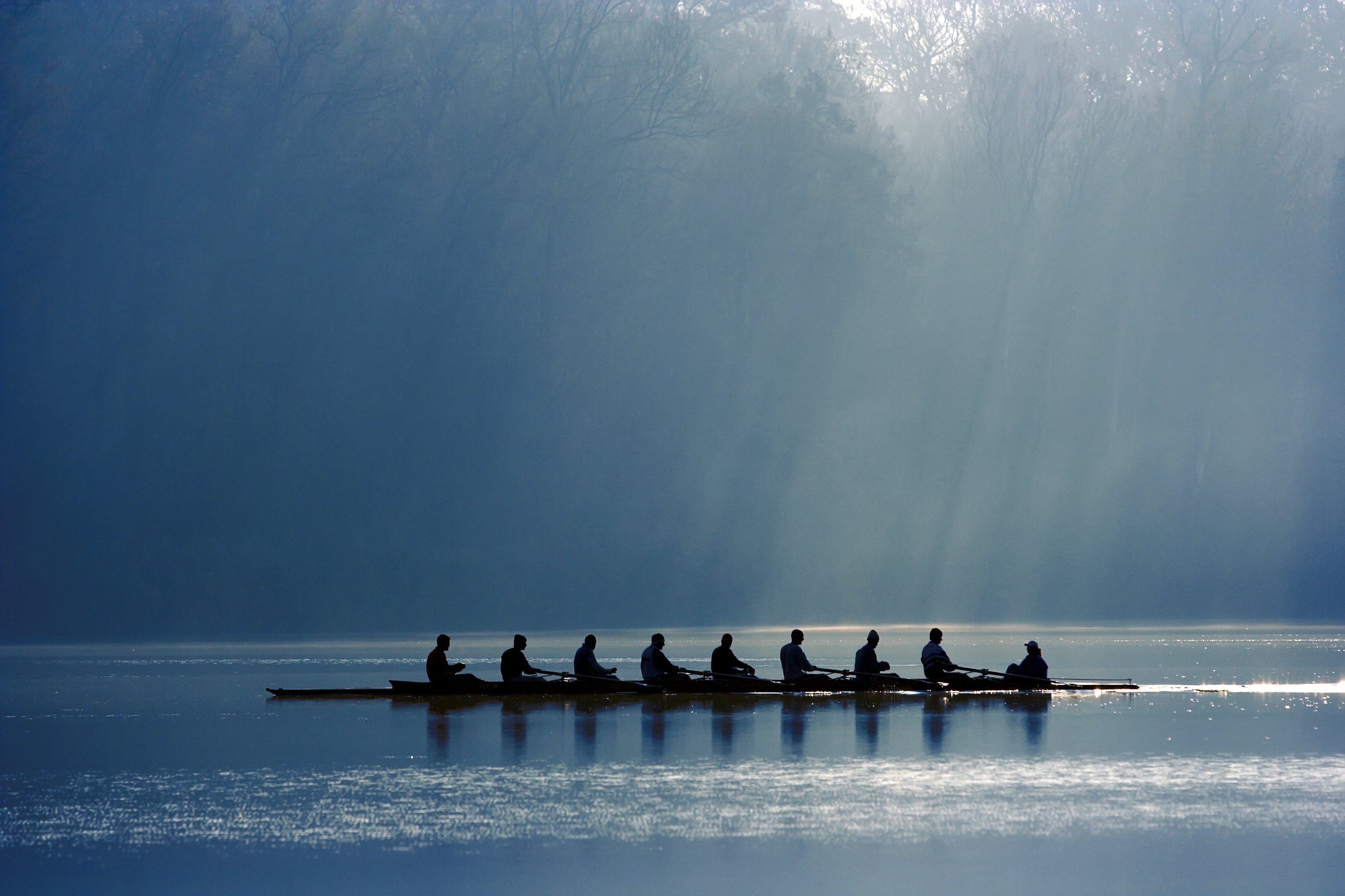 Crew rowing a boat down the river