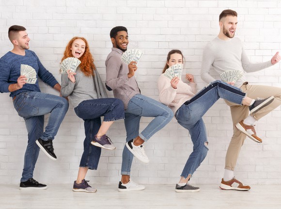 Group of excited friends with cash in hand