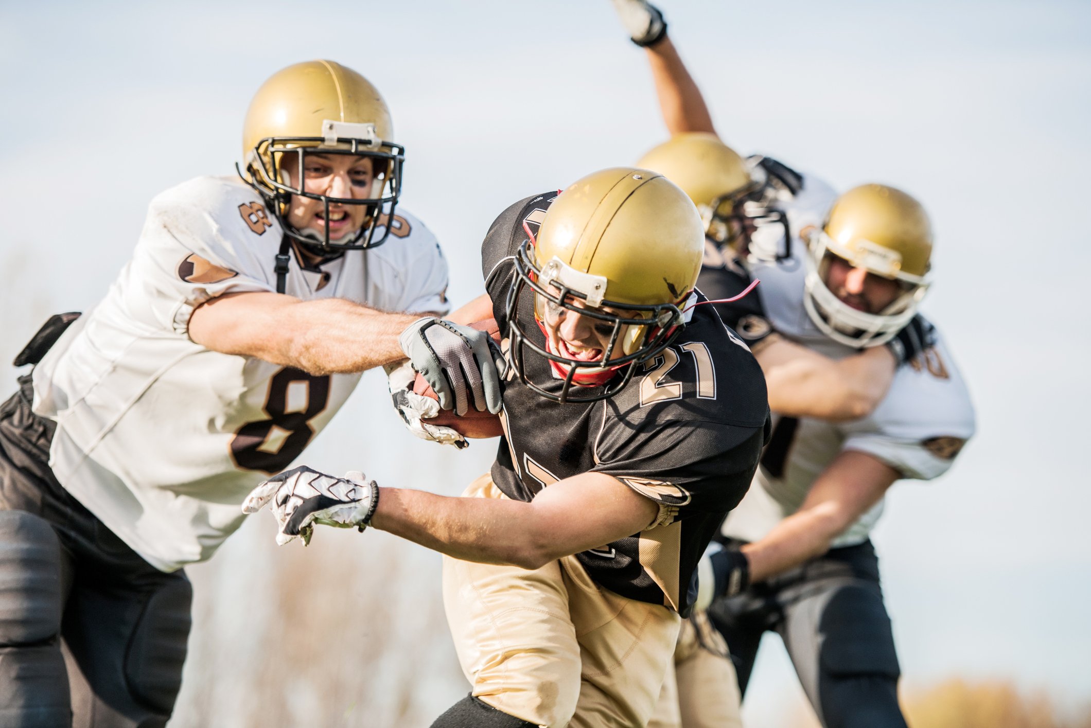 College football players tackling the receiver.