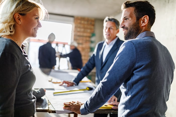 A group of people in business suits having a meeting at a construction site. 